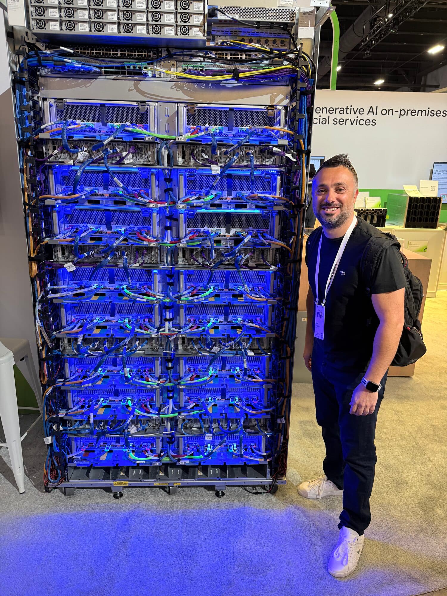 Peter beside a towering, blue-lit cloud server rack at Google Cloud Next