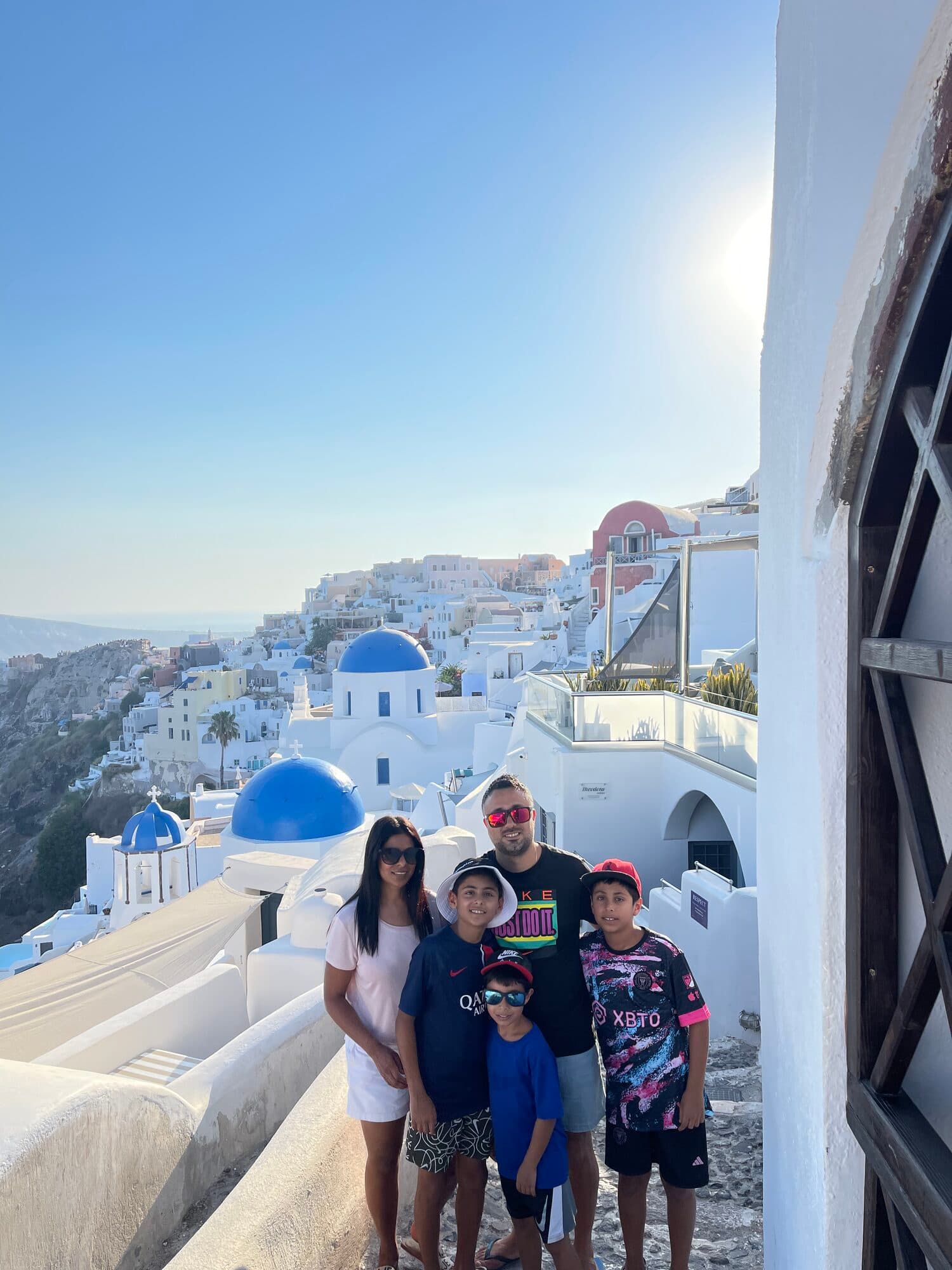 Peter with his wife and three boys above the blue domes of Santorini
